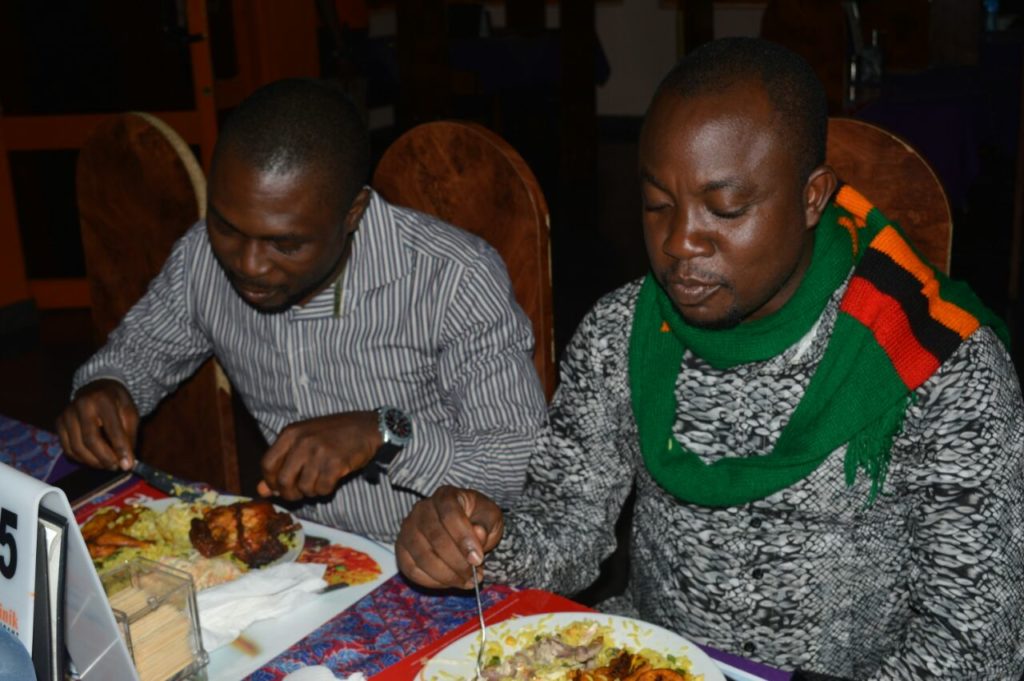 Kolo and Dotun Roy digging into fried rice and chicken 